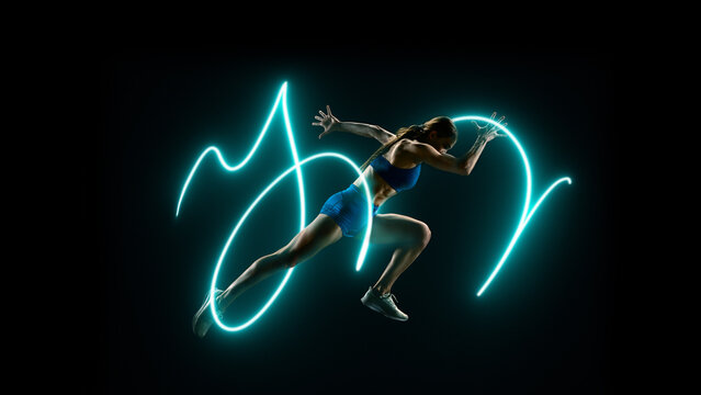 Female athlete sprinting surrounded by light motion neon lines symbolizing strength. Concept of fitness motivation, gym advertising, and healthy lifestyle promotion.