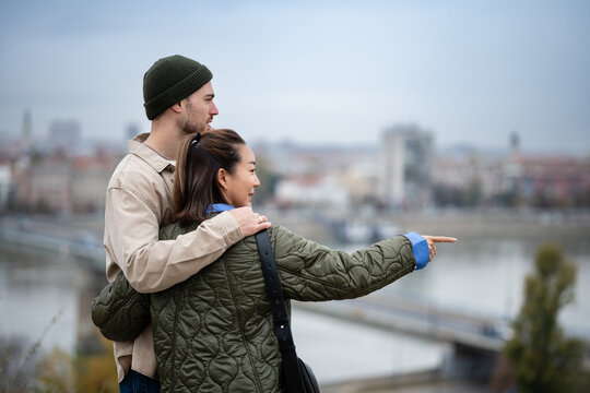 Diverse couple on city trip pointing at view - Powered by Adobe