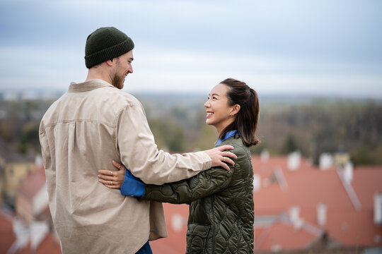 Happy young couple embracing outdoors overlooking city
