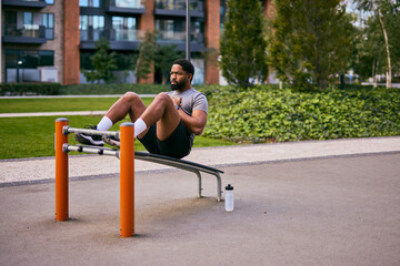 Man Performs Abdominal Exercise on Outdoor Bench in Urban Park Setting for Fitness Photo