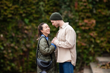 Interracial couple holding hands enjoying romantic outdoor moment