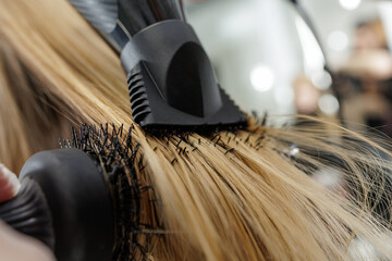 Close up round brush blowout with concentrator nozzle on long blonde hair