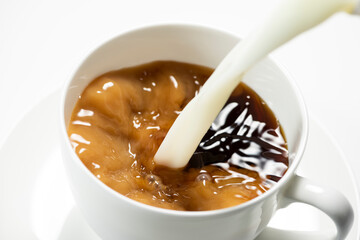 珈琲にミルクをそそぎ入れる