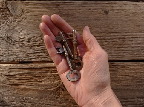 A close-up of a few old keys in a woman's hand.