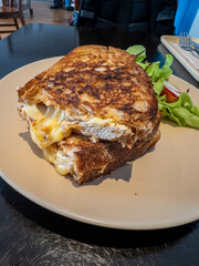 A tantalizing grilled sandwich, oozing with melted cheese and succulent chicken, served on toasted artisanal bread. Accompanied by a fresh side salad, this hearty meal is perfect for a satisfying