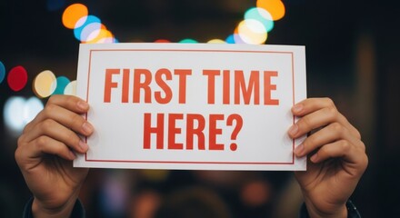 Hands hold sign asking first time here question with bokeh lights background