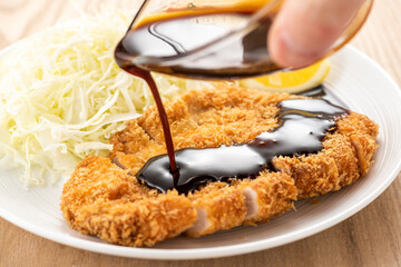トンカツにソースをかける