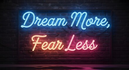 A vibrant neon sign displays the motivational message 'Dream More, Fear Less' against a dark brick wall background, inspiring positivity and confidence