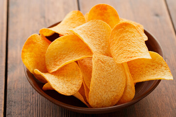 Golden Crispy Potato Chips in Bowl on Wooden Table