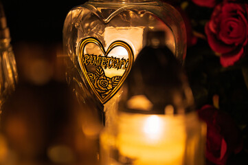 Night scene of a cemetery illuminated by hundreds of candles during All Saints Day. Warm glowing lights, bokeh and flowers creating a peaceful, spiritual atmosphere. Shot in Biały Kościół, Poland.