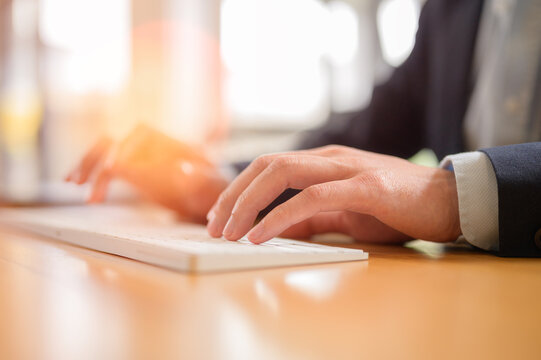 Man hands typing on wireless computer keyboard, Document data system Report HR technology Concept: Businessman Manager checking white documents reports papers of files icon in modern office
