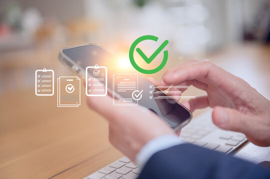 Close-up of businessman using smartphone with digital checklist and approval icons, representing mobile document management, online verification, and business task completion concept