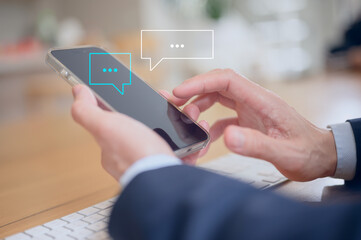 Social Media businessman hand using smartphone typing live chat chatting on application communication digital web and social network concept. Social media application chat box