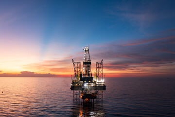 Obraz premium Aerial view of offshore jack up rig and offshore platform during sunset for oil and gas exploration and production.