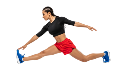 Athletic young woman in black crop top and red shorts leaping with extended legs showcasing flexibility and strength, perfect for fitness and sports themes