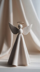 Minimalist angel tree topper with soft fabric dress, delicate wings and simple halo