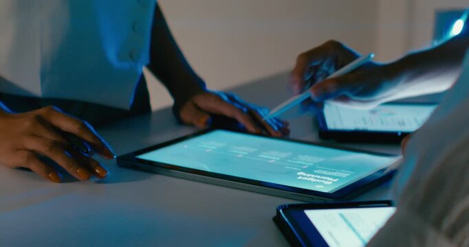 Closeup group Asian businesspeople work together discuss plan idea with data profit sale statistics in business meeting in office night. Financial generation z team brainstorm on e-Commerce project.