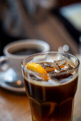 Refreshing iced espresso tonic with orange slice served in glass on cafe table