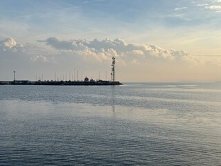 Calm sea with lighthouse and beautiful evening sky on the horizon.
