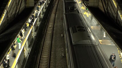 TOKYO, JAPAN - NOV 2025 : Aerial top view of train station at night. Crowd of people at the platform in rush hour. Japanese urban city, transportation, traffic and commute concept time lapse video. - Powered by Adobe