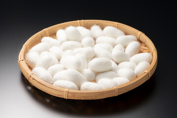 笊いっぱいの白い繭玉　黒背景