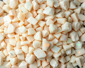 Pile of small rough cut opals with flashes of color