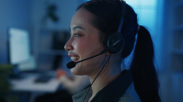 Closeup Gen z Asia young call center team or customer support service executive use computer and microphone headset work technical e commerce in late night office. Telemarketing or sales job concept.