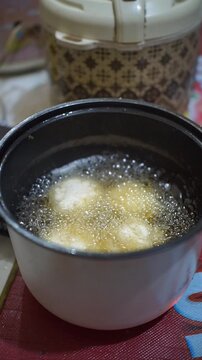 Traditional Indonesian snack combro being deep-fried in an electric fryer until golden and crispy.