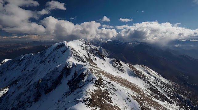 Snow-capped mountain peak under a cloudy sky aerial view of a majestic landscape perfect for travel and adventure themes - Powered by Adobe