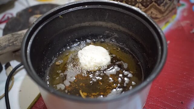 Traditional Indonesian snack combro being deep-fried in an electric fryer until golden and crispy.