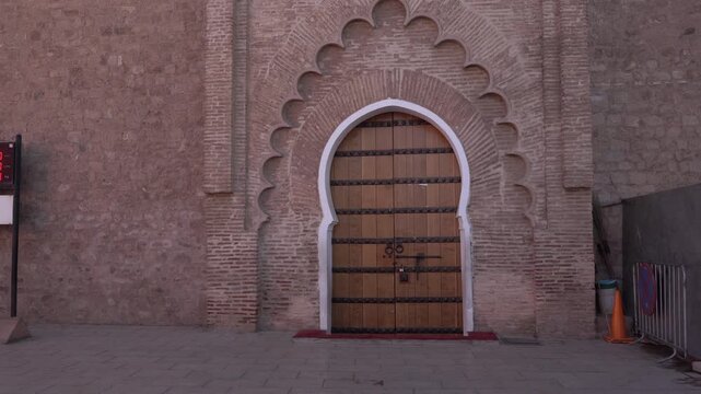 A Moroccan door that is truly beautiful because of its patterns. The whole thing is set on a brick wall.