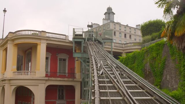 The historic Pau Funicular railway ascending its steep track, set against a backdrop of lush green foliage and classic French architecture in Pau, Nouvelle-Aquitaine, France.