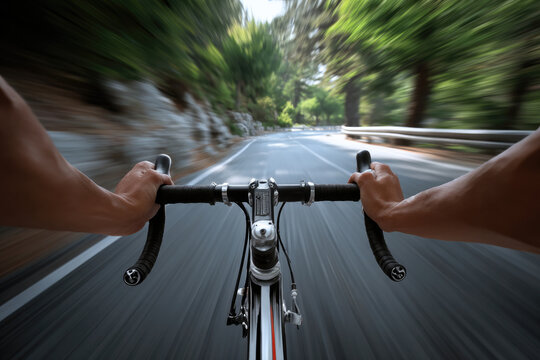 Cyclist hands gripping handlebars on fast road, motion blur, outdoor summer ride, green forest, speed, adventure, focus