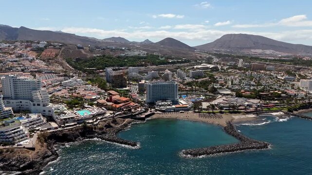 Vacation in the Canary Islands by the Atlantic Ocean with a sandy beach, attractions, accommodation and mountains in the background