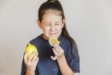 Cute little girl eating fresh lemon isolated on white background