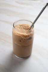 Dalgona coffee. Whipped instant coffee in a glass.  The concept of a trendy and popular drink. Free space for text. Perfect for recipes, articles or any cooking content.