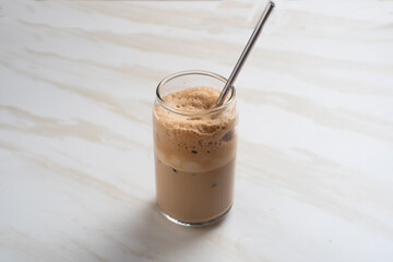 Dalgona coffee. Whipped instant coffee in a glass.  The concept of a trendy and popular drink. Free space for text. Perfect for recipes, articles or any cooking content.