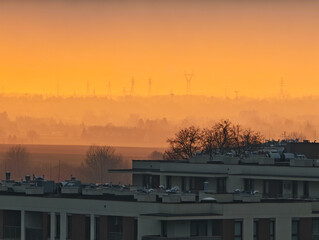 The cityscape seen from the observation deck in the intense orange light of the setting sun.