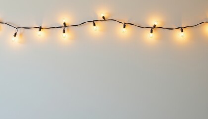 String of warm glowing patio lights draped horizontally against a plain light background