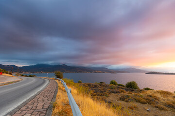 A picturesque seaside landscape at sunset with calm water, lush vegetation and mountains under a clear sky on the Greek volcanic island of Lesbos, a background or wallpaper from the project