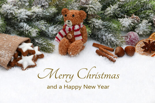 Christmas card: Christmas greetings with Christmas decorations, a teddy bear, fir branches, and cookies in the snow. Merry Christmas and a Happy New Year.