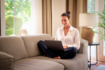 Confident middle-aged woman using her laptop at home