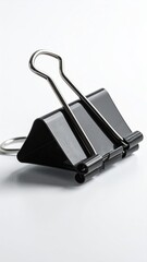 Black binder clip, silver levers, on a white background