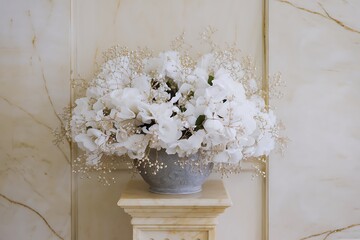Elegant White Floral Arrangement in a Gray Vase on a Marble Pedestal Against a Decorative Wall