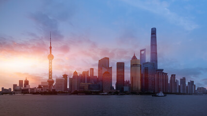 Fototapeta premium Shanghai colorful skyline with motion speed light of passing ferry in the foreground at sunset - Shanghai, China
