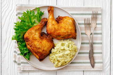 roast chicken legs with coleslaw on a plate