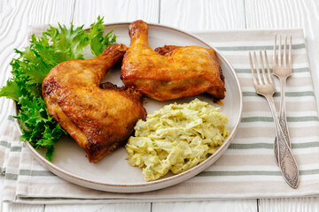 roast chicken legs with coleslaw on a plate