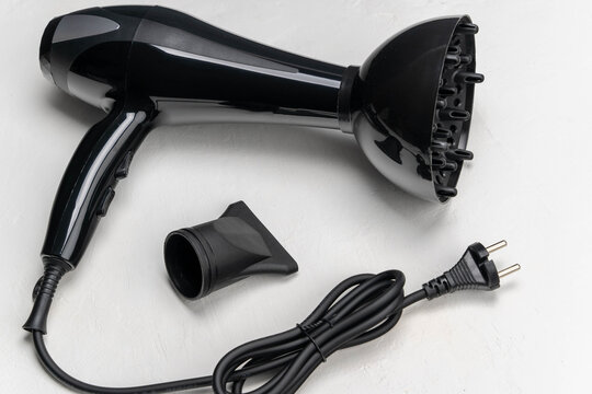 Black hair dryer with diffuser attachment and power cord, showcasing sleek design and functionality for hairstyling, ideal for personal grooming and professional use