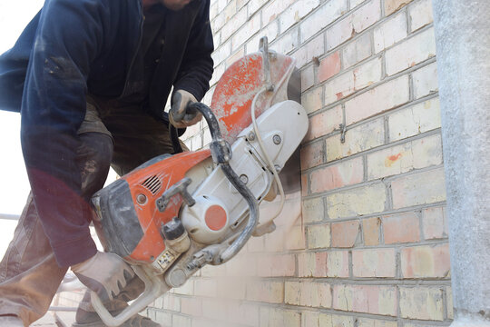 Cutting a hole in the wall using a cutter.