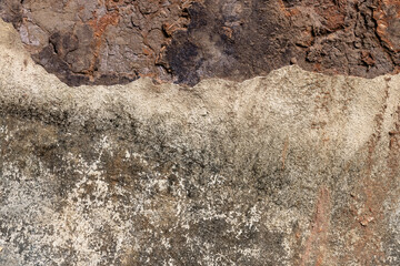 Real textured background of a dry, cracked red clay wall with a broken concrete surface, peeling off with border. For use concept of erosion, damage, and decay for abstract or grunge design themes